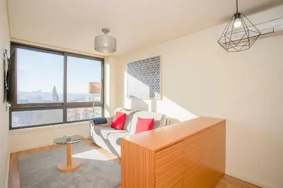a living room with a couch and a large window at Liiiving in Porto | Downtown View Apartment in Porto