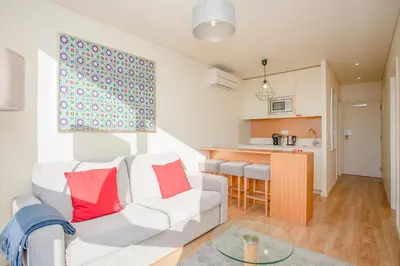 a living room with a white couch and red pillows at Liiiving in Porto | Downtown View Apartment in Porto