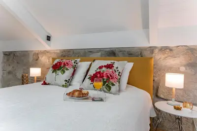 a bed with a tray of food and two lamps at Mouzinho Cosy LOFT in Porto