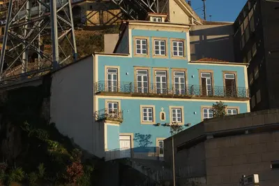 a blue house on a hill next to a bridge at Porto View by Patio 25 in Vila Nova de Gaia