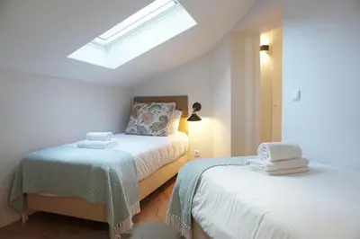 a bedroom with two beds and a skylight at Porto View by Patio 25 in Vila Nova de Gaia