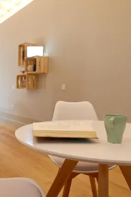 a table with two chairs and a book on it at LOFT Sá de Noronha in Porto