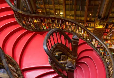 a spiral staircase in a library with books at LOFT Sá de Noronha in Porto