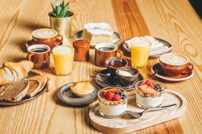 a table topped with cups of coffee and breakfast foods at 7 Gaia Roaster Apartments in Vila Nova de Gaia