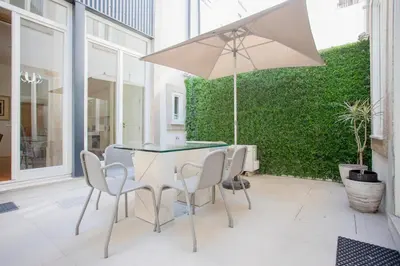a table and chairs with an umbrella on a patio at Liiiving in Porto | Central Secret Terrace in Porto