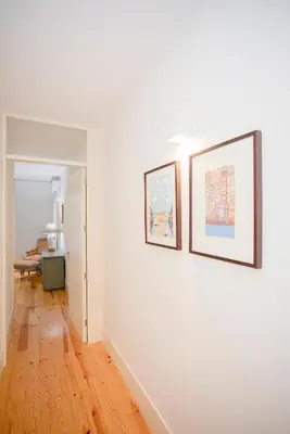 a white room with two framed pictures on a wall at Liiiving in Porto | Central Secret Terrace in Porto