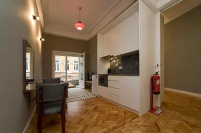 a living room with a tv and a desk with a chair at De Porto e Alma in Porto