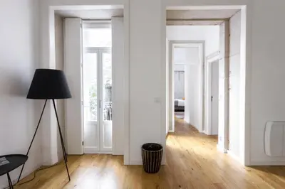 a living room with a floor lamp and white walls at Oporto City View - Santa Catarina in Porto
