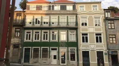 a tall green and white building with a balcony at Oporto City View - Santa Catarina in Porto