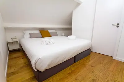 a bedroom with a bed with two towels on it at Oporto City View - Santa Catarina in Porto
