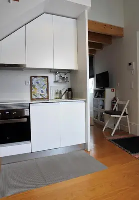 a kitchen with white cabinets and a counter top at Green House / Casa Verde in Porto