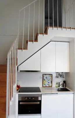 a kitchen with white cabinets and a staircase at Green House / Casa Verde in Porto