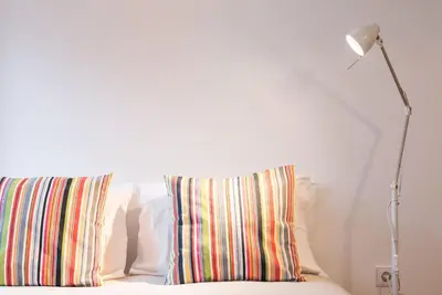 a white bed with a pillow and a lamp at GuestReady - Chic city nest in Porto in Porto