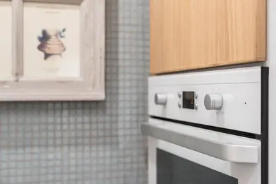 a kitchen with a white stove and a cabinet at GuestReady - Crayon Walls Apartments in Porto