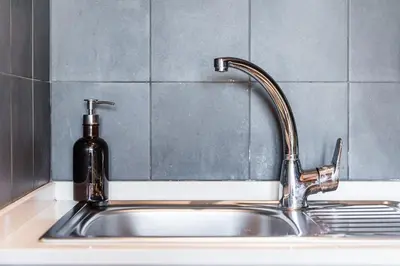 a kitchen sink with a soap dispenser next to it at GuestReady - Crayon Walls Apartments in Porto