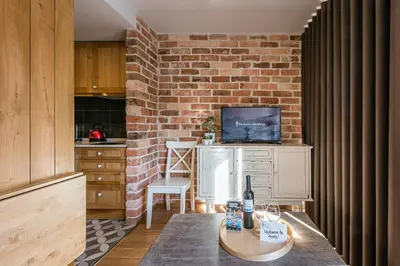 a kitchen with a brick wall and a table with a bottle of wine at GuestReady - Crayon Walls Apartments in Porto