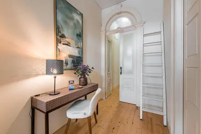 a desk with a lamp and a chair in a room at GuestReady - La Maison Aires Gouveia in Porto