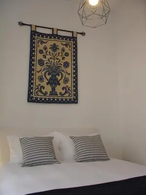 a picture hanging above a bed with two pillows at Downtown Historical Apartment in Porto