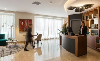 a woman standing at a desk in an office at Pestana Porto - A Brasileira, City Center & Heritage Building in Porto