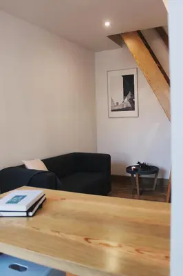 a living room with a black couch and a table at Lost Apartments in Porto