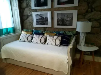 a bedroom with a bed and a stone wall at the gallery Studios II in Porto