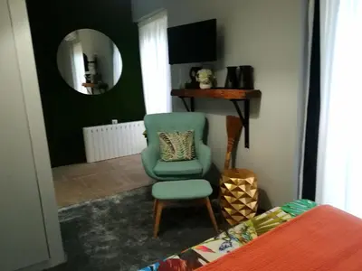 a bedroom with a green chair and a mirror at the gallery Studios II in Porto