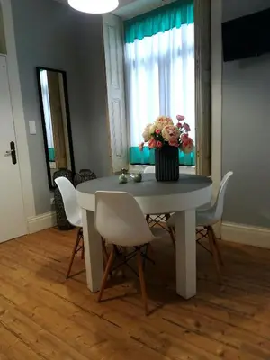 a dining room table with a vase of flowers on it at the gallery Studios II in Porto