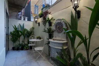 a patio with a fountain and plants and a table and chairs at the gallery Studios II in Porto