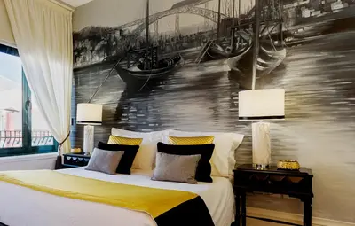 a bedroom with a bed with a painting on the wall at the gallery Studios II in Porto