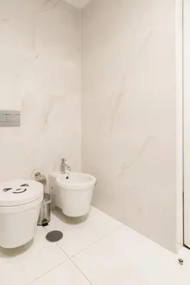 a white bathroom with a toilet and a sink at Apartamento Qian Caves Gaia 2BR AC Free Parking in Vila Nova de Gaia