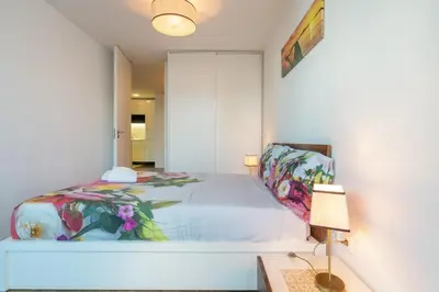a bedroom with a large bed and a lamp at Apartamento Qian Caves Gaia 2BR AC Free Parking in Vila Nova de Gaia