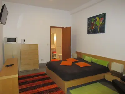 a bedroom with a bed with orange and green pillows at Flower's Downtown Porto in Porto