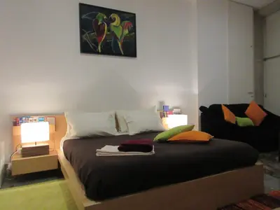 a bedroom with a bed with two lamps and a chair at Flower's Downtown Porto in Porto