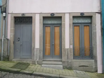two doors on a building with orange curtains at Flower's Downtown Porto in Porto