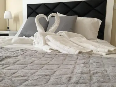 two swansuitsrendered to look like swan towels on a bed at Invicta house Boavista in Porto
