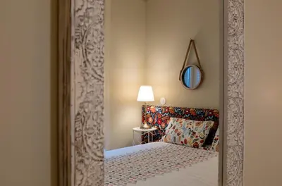 a bedroom with a bed with a mirror and a lamp at HOMEinTOWN Almada - Downtown Elegant Apartment - Terrace AC & WIFI in Porto