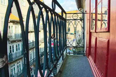 a person standing on a balcony looking out onto a city at Hannah's Studios in Porto