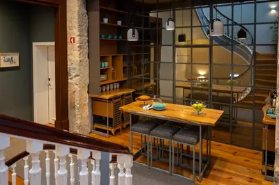 a dining room with a table and a staircase at Santa Catarina FLH Suites in Porto