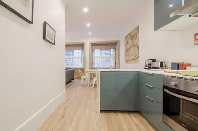 a kitchen with white walls and blue cabinets at OHH -S João apartments- Riverside in Porto