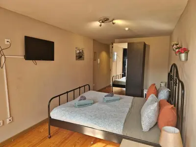 a bedroom with two beds and a flat screen tv at AlfandegaPorto Apartments in Porto