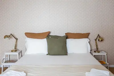 a bedroom with a bed with white sheets and pillows at Impar Triplex House in Porto