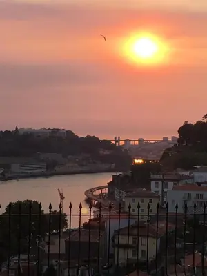 a sunset over a river with a bridge in the background at Virtudes Patio in Porto