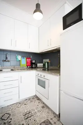 a kitchen with white cabinets and a refrigerator at Virtudes Patio in Porto