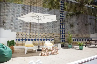 a patio with two chairs and a white umbrella at Virtudes Patio in Porto