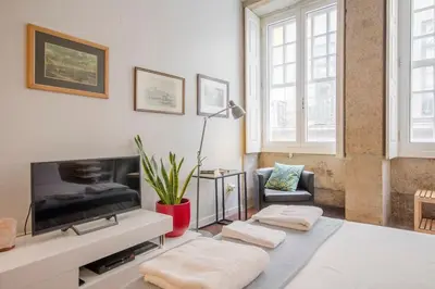 a living room with a tv and two ottomans at OHH - Ganesha studio- Oporto Center in Porto