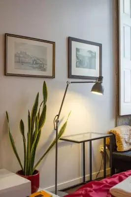 a living room with a lamp and a potted plant at OHH - Ganesha studio- Oporto Center in Porto