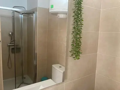 a bathroom with a shower and a toilet with a plant at PATH Biblioteca Apartment in Porto