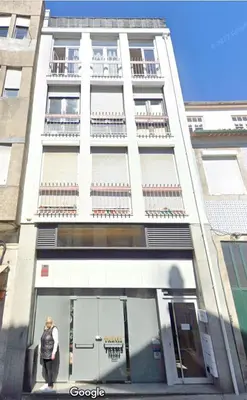 a person standing in front of a building at PATH Biblioteca Apartment in Porto