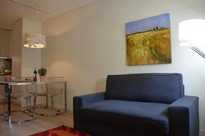 a living room with a blue chair and a table at Oporto Like Home II in Porto