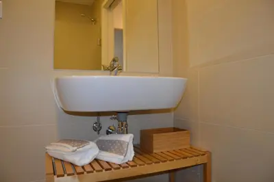 a bathroom with a sink and towels on a shelf at Oporto Like Home II in Porto